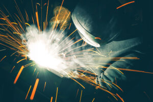 Professional Welder is Welding Two Metal Parts Together. Sparks Flying All Around. Metal Industry Theme.
