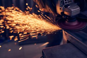 Worker cutting metal with grinder. Sparks while grinding iron.